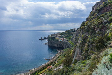 View at coastline in Taormina with clear turquoise water at the mediterranean sea on a sunny day, Sicily, Italy