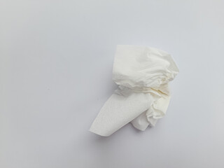 Used tissue paper discarded, crumpled and resting on white background. Top view of screwed or crumpled white tissue paper after use