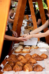 choosing and buying fresh bread and pastries at farmers food market.