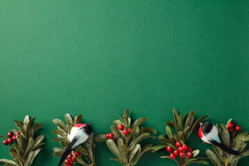 Minimalist Christmas background with holly and birds. Flat lay, top view, copy space.