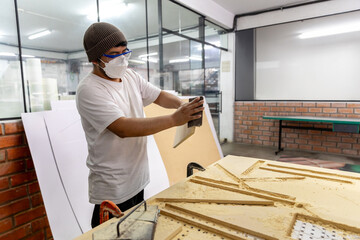 Fototapeta premium Operator working on a plasma cutting machine for different substrates such as MDF board.