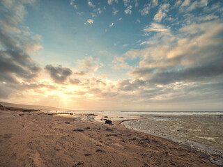 Stunning Fanore beach in county Clare, Ireland. Popular travel and tourist hotspot with amazing Irish nature scenery view. Sandy beach with rocks, powerful ocean with waves and dramatic sky.