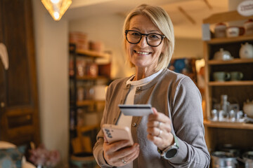 Portrait of mature woman shop online with credit card in the wine shop