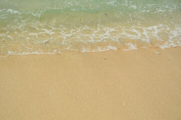 clear water and golden beach sand for background, gentle water waves
