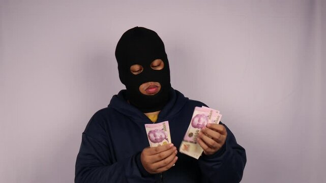 close up on the thief wearing jacket counting bundles of ten thousand Singapore dollar banknotes with white background.

