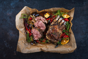 Traditional barbecue rack of lamb with eggplant and pepperoni served as top view on a rustic metal tray with butcher paper