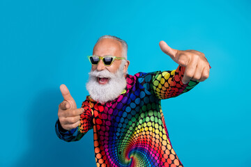 Photo of funny stylish aged man point fingers you wear colorful shirt isolated on blue background