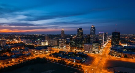 Fototapeta premium Aerial view of a cityscape with lights glowing at twilight