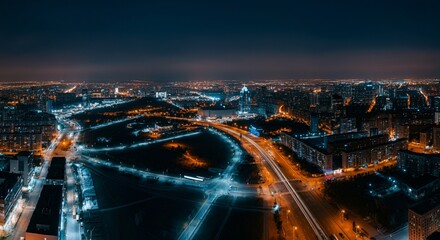 Fototapeta premium Aerial view of a cityscape with lights glowing at twilight