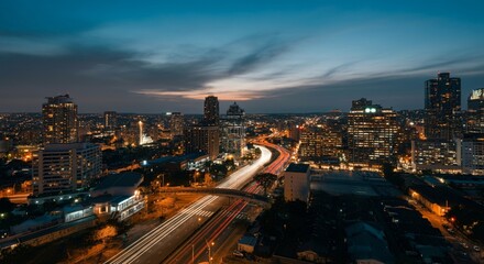 Fototapeta premium Aerial view of a cityscape with lights glowing at twilight