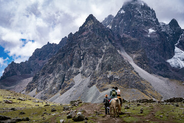 Travelers riding on the route of the Ausangate snow-capped mountain in Cusco, Peru.