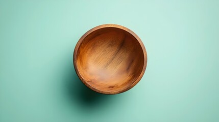 A wooden bowl is sitting on a green wall