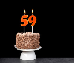 Birthday card with candle number 59 - Chocolate cake on black background.