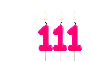 Pink number 111 birthday candle lit on white background