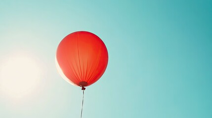 Obraz premium Bright Red Balloon Floating in Clear Blue Sky