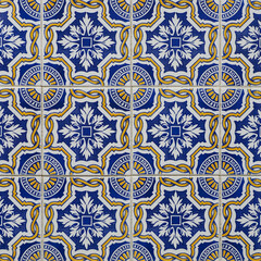 Fragment of building wall with colorful ceramic tiles. Azulejos, close up. Traditional ornate Portuguese architecture. Abstract background, textured ornate pattern for design or backdrop.