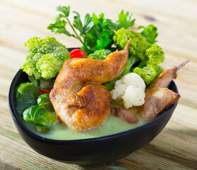 Vegetable broth with cauliflower, Brussels sprouts and broccoli served with fried quail meat, tomatoes and parsley