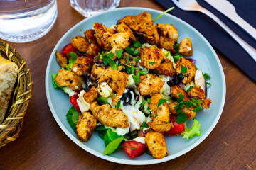 Warm Caesar salad with fried chicken and mushrooms closeup