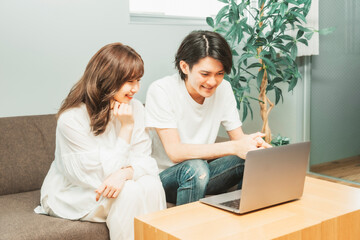 部屋にいる男女（ノートパソコン）

