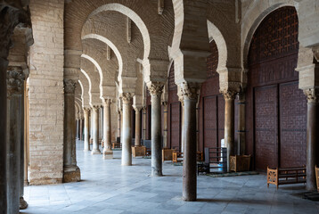 Corridor gallery around inner courtyard of Great Mosque of Kairouan in Tunisia with traditional Islamic arches and columns decorated with Corinthian capitals