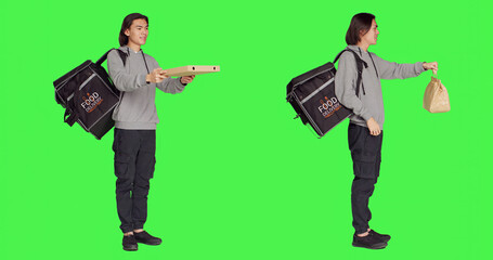 Posing over greenscreen studio backdrop, asian person working on delivering food with thermal backpack. Young adult carrying huge bag for delivery service, eager to provide good service.