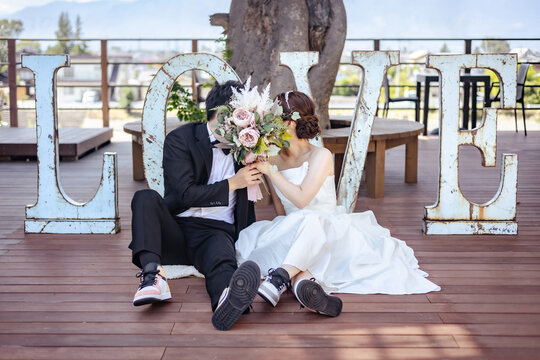 LOVEのオブジェの前でウェディングフォトを撮る新郎新婦
