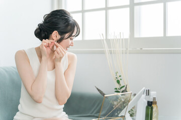 家でアクセサリー・ピアスを選ぶ女性
