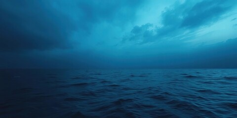 Obraz premium Ocean surface reflecting dark blue sky above, blue sky, atmospheric perspective