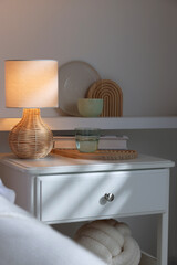 Stylish living room interior with bed, bedside table and lamp