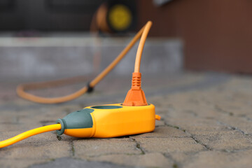Extension cord on paved pathway outdoors, closeup