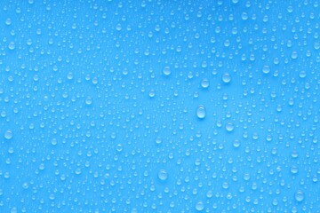 Water drops on blue background, top view