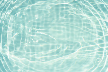 Blue water with ripples on the surface. Defocus blurred transparent blue colored clear calm water surface texture with splashes and bubbles. Water waves with shining pattern texture background.