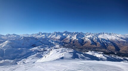Obraz premium A stunning panoramic view of snow-covered mountains under a clear blue sky.
