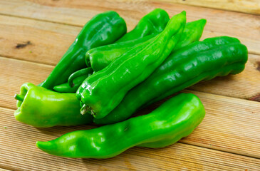 Image of fresh whole peppers on a wooden surface. Close-up image