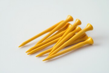 Set of vibrant yellow golf tees arranged on a soft white background, perfect for sports and recreation photography