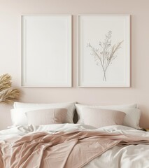 Two framed prints with minimalist botanical art hanging above a bed with blush pink bedding