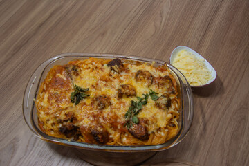 A delicious plate of pasta with meatballs, topped with grated parmesan cheese, showcasing a comforting Italian meal. The vibrant colors highlight the dish's textures..