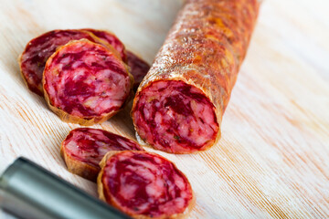 Traditional Spanish dry cured pork sausage Salchichon on wooden board..
