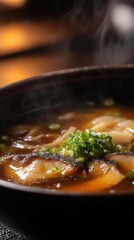暗い背景に野菜と湯気が入ったおいしい温かい麺スープ