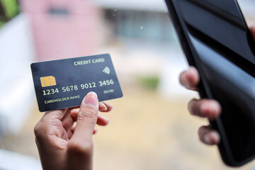 Hand Holding Credit Card and Smartphone Shopping Online Using Internet