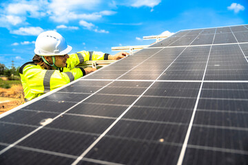 A solar technician in a high-visibility jacket and helmet stands next to a solar panel, with a...
