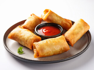 Chinese egg rolls with chili sauce on a white background
