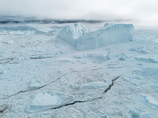 Obraz premium Drone shot of huge iceberg floating and melting, Jakobshavn Glacier, Ilulissat, Greenland