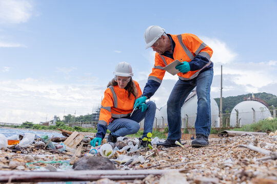 Environmental Cleanup Team Collecting Litter Along the Shoreline, Highlighting Efforts to Remove Plastic Waste, Protect Ecosystems, and Promote Conservation in Industrial Area
