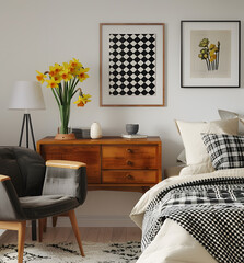 A stylish bedroom featuring midcentury furniture, modern art prints, and a cozy atmosphere. Ideal for interior decor enthusiasts who enjoy blending styles and creating a comfortable space