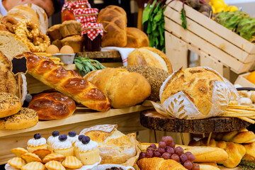 Variety of fresh bread baked goods pastries arranged beautifully at local farmers market