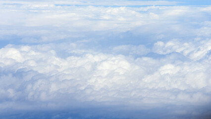 Aerial view layers of soft white clouds floating, serene blue sky, peaceful