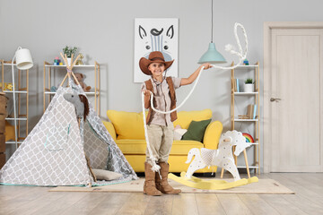 Cute little cowboy with lasso at home
