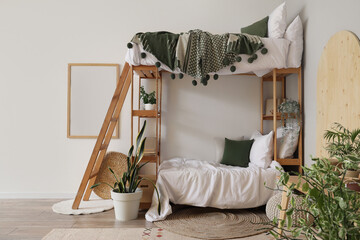 Interior of light children's room with bunk bed and plants