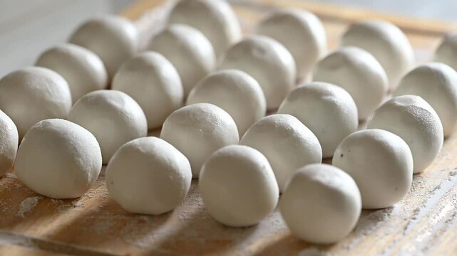 Making Tangyuan (Chinese sweet dumpling), Glutinous rice dough filling with black sesame on wooden board prepare for boiling